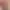 Eine menschliche Hand berührt ein großes rotes Herz auf einem hellen texturierten Hintergrund